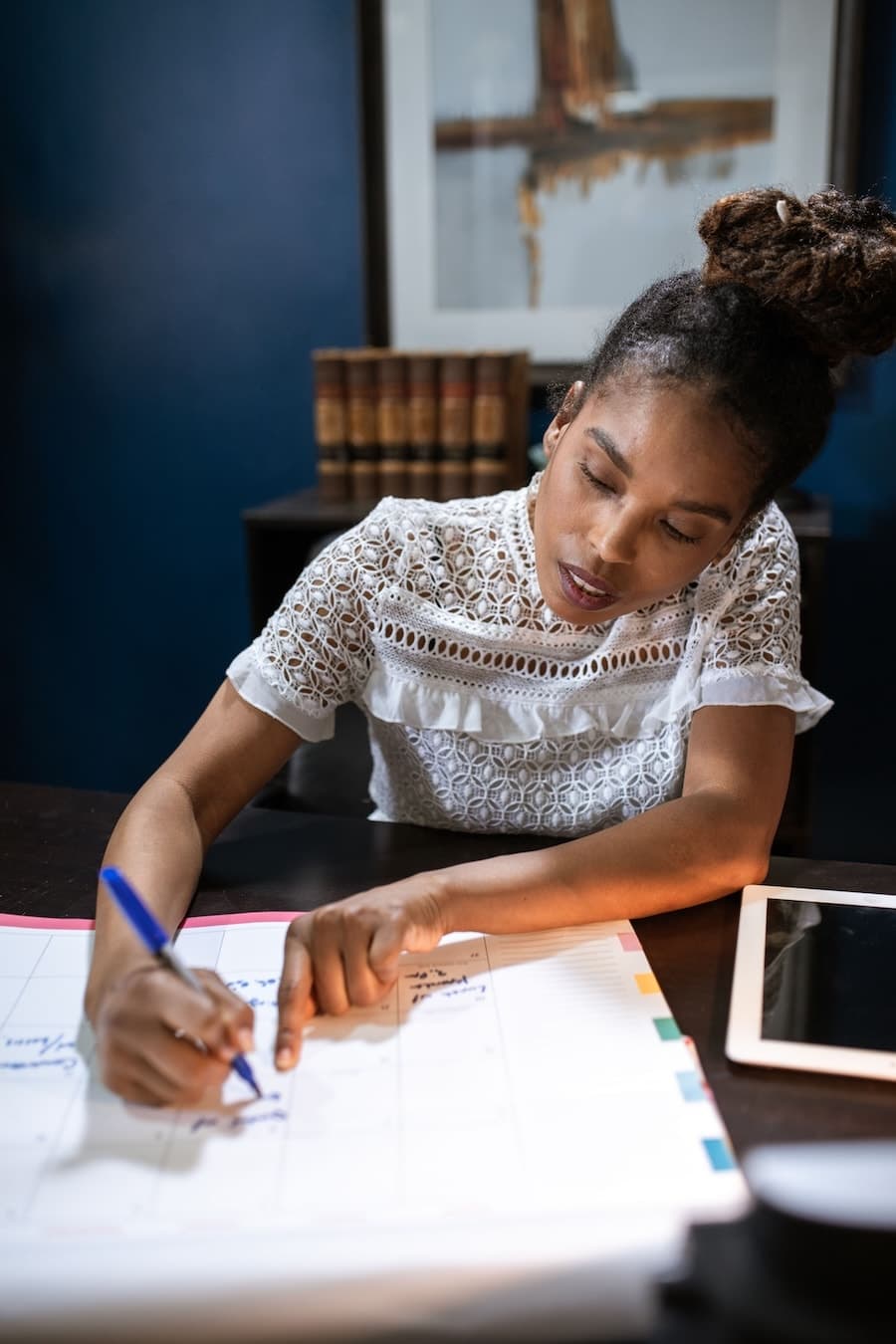 Femme organisant une tâche sur une grande feuille, un stylo à la main